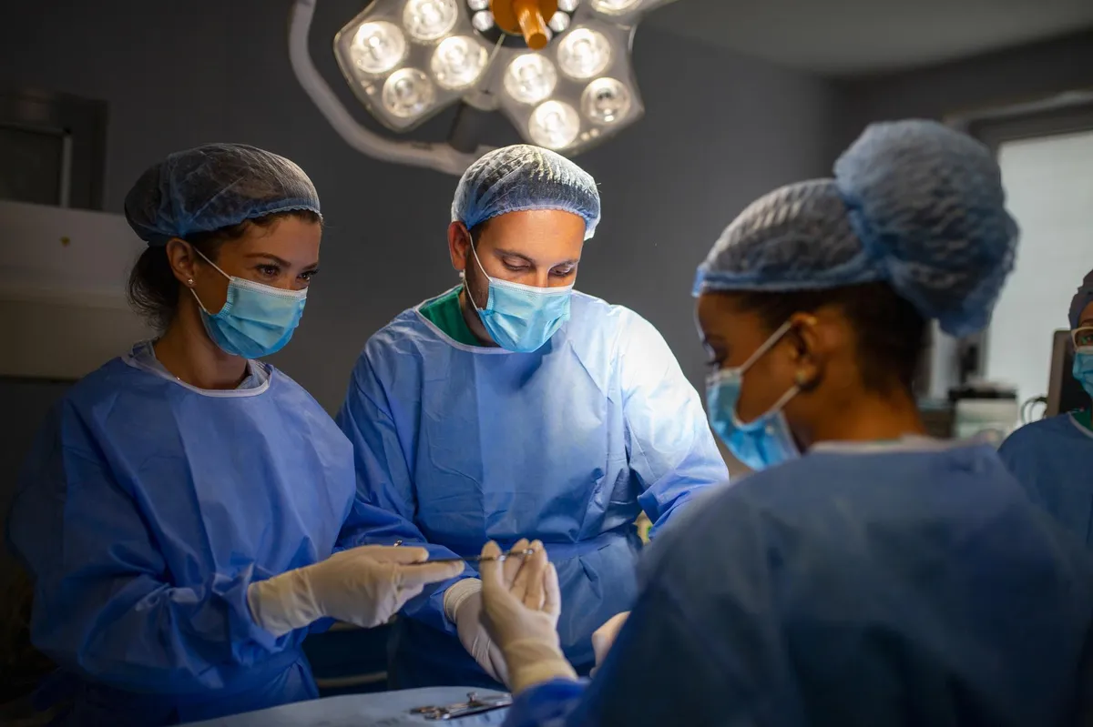 Echipă chirurgicală în sala de operație efectuând o intervenție pentru cancer colorectal